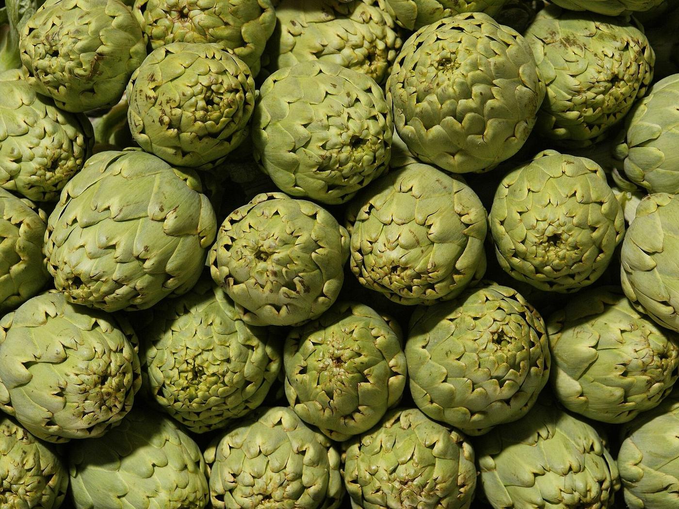 Artichokes piled up on a market stall