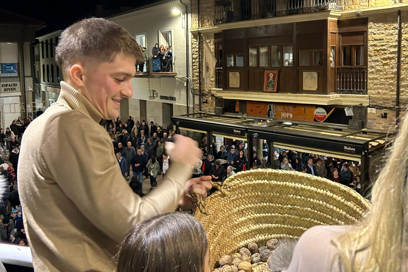 Walnuts being thrown from the balcony of the Casa de la Villa in Fustiñana, with the basket of walnuts and the square packed with people